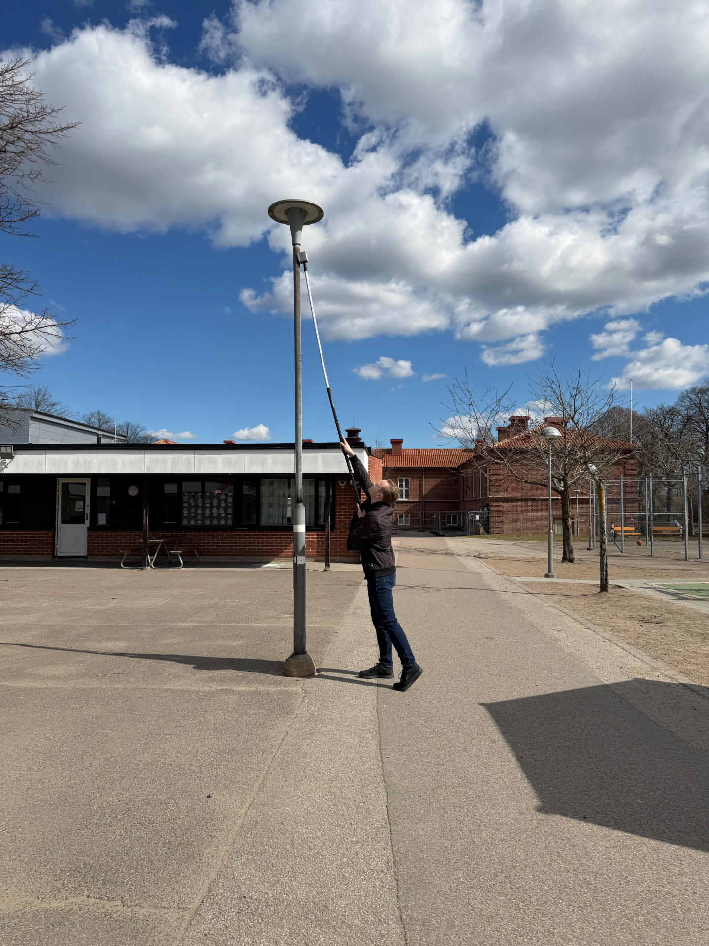 Sensor monteras på en gatlykta på en skolgård