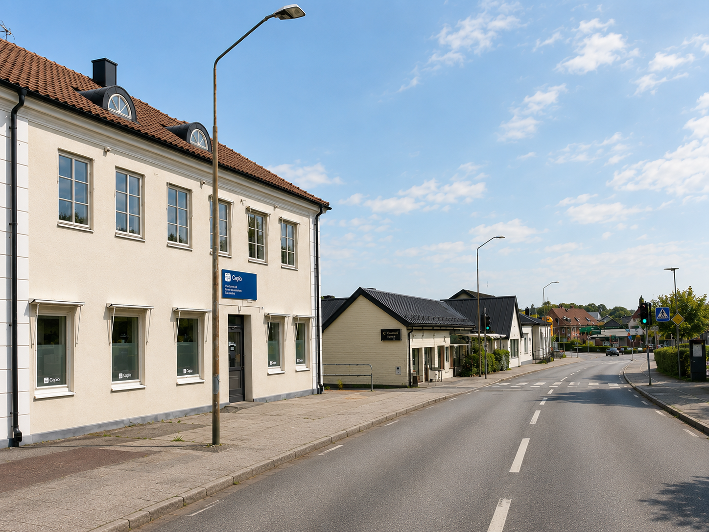 Samma gata i Veberöd idag, med vårdcentral, asfalterad väg och övergångsställe